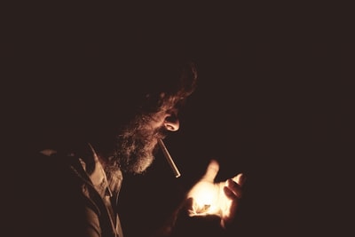 男人与烟在嘴里拿着打火机
